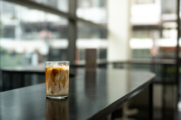 Iced coffee with milk in a glass on a table in a cafe