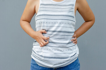 young asian woman scratching itch with hand on abdomen area, health care concept, dermatosis