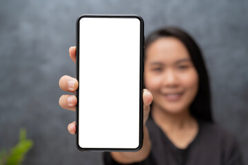 App Ad. Smiling pretty woman holding smartphone with white blank device screen in hand close up to camera. Gadget with empty free space for mockup