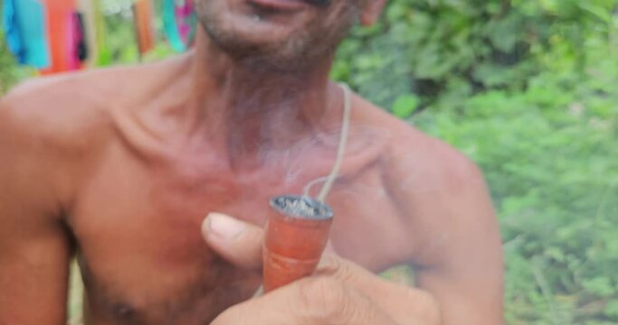 Indian Village man taking or smoking Chilum(Marijuana, Cannabis.