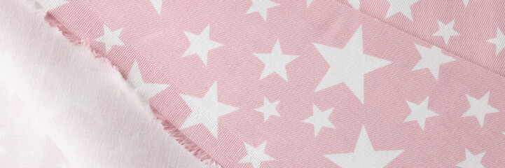 Cutted pink-white fabric with different stars pictures as background.
