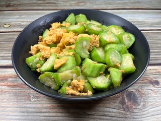 Traditional fried and stirred organic zucchini seasoning with chicken egg serving on the plate. Famous omelet vegetable menu in Asian restaurant.