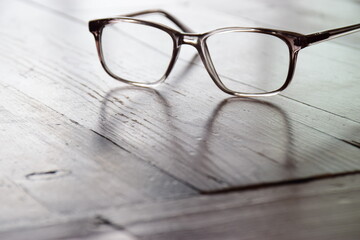 Reading glasses on a wooden tabletop