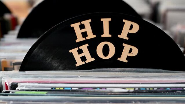 Close up pan past hip hop section in record store