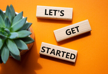 Lets get started symbol. Concept words Lets get started on wooden blocks. Beautiful orange...