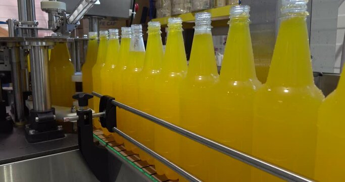Bottling lemonade at the factory. Production of beverages - carbonated lemonade, carbonated water in plastic bottles - on an automatic conveyor.