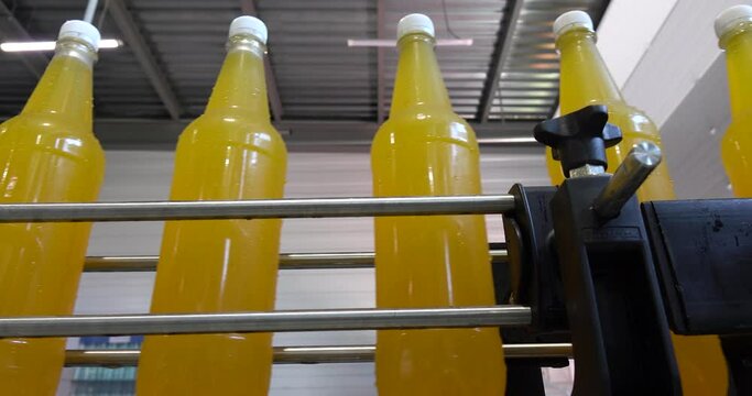 Bottling lemonade at the factory. Production of beverages - carbonated lemonade, carbonated water in plastic bottles - on an automatic conveyor.