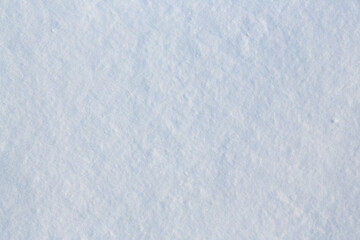Fototapeta premium Natural snow texture. The surface of clean fresh snow. Snowy ground. Winter background with snow patterns. Perfect for Christmas and New Year design. Closeup top view.