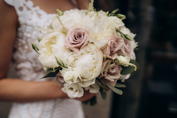 Beautiful bride holds white bouquet. bouquet from white rosses in woman's hands