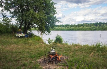 Fototapeta premium Summer vacation on the river bank with a bonfire