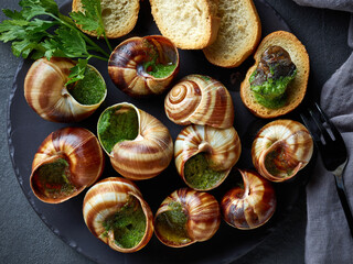 plate of baked escargot snails filled with parsley and garlic butter