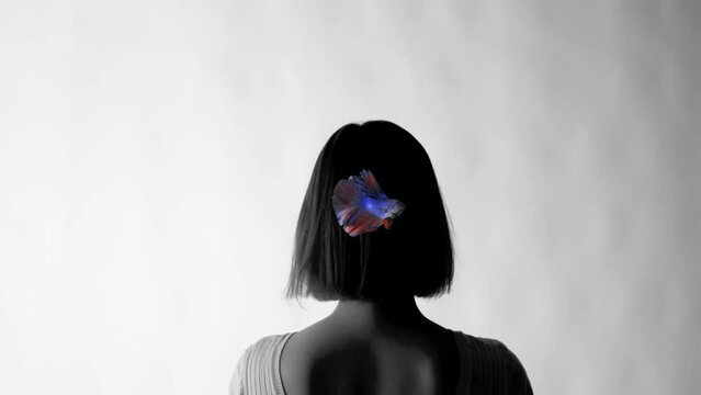 The psychological concept of discovering the personal aspects of a person. Black and white female image with a feather colored fish in her head.