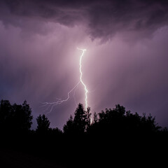 beautiful lightning during a thunderstorm at night in a forest that caused a fire, against a dark sky with rain