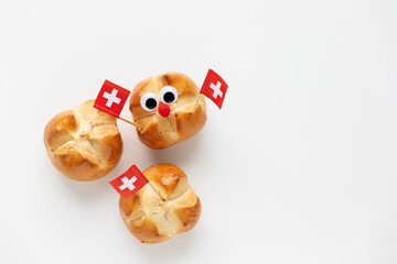 The first august bread buns baked to celebrate national holiday of Switzerland decorated with swiss flag