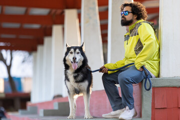 mexican afro hairstyle man with his husky dog, international pet dog day