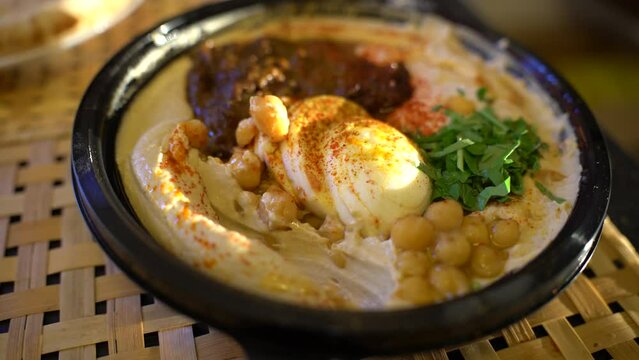 Dipping pita bread into a plate of hummus
