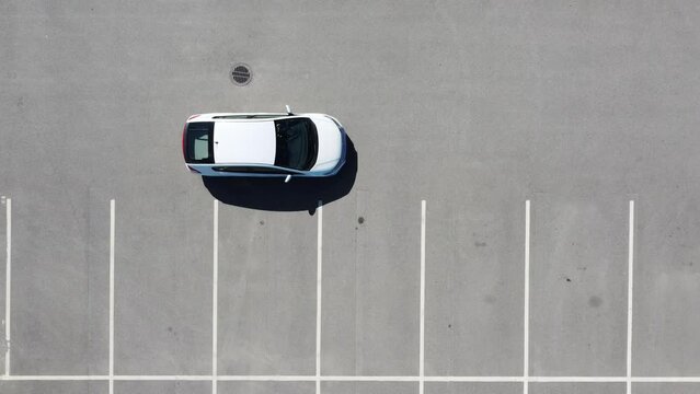 Top view car reversing in a parking space