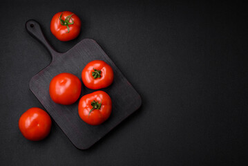 Delicious fresh juicy tomatoes on a dark concrete background