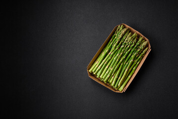 Delicious fresh sprigs of asparagus on a dark textured background