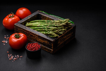 Delicious fresh sprigs of asparagus on a dark textured background