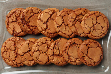Crunchy homemade cookies on glass plate on gray background