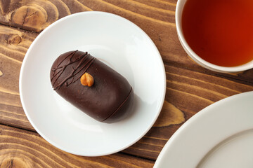 Delicious chocolate cake in white plate on wooden table background