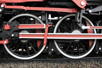 Detail of the metal wheels of the train locomotive. The wheels are painted black, white and red.