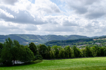 cumulus clouds against the blue sky, houses, forests, and fields in germany.