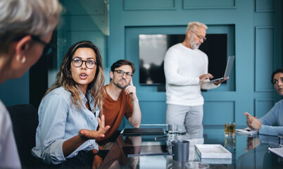 Young female business professional discussing her ideas with her colleague in a meeting