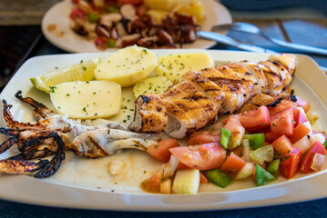 Grilled squid with boiled potatoes and vegetables served in a restaurant in the Algarve, Portugal.
