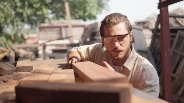 A carpenter checking a prank of wood before working. Carpentry, Craftsmanship, woodworking.