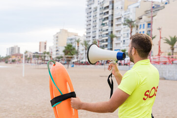 Lifeguard using a loudspeaker on the beach