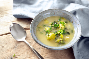Vegetarian soup from vegetables like brussels sprout, leek and potato with parsley garnish in a...