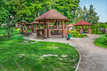 Picnic area in Trostyanets central park, Sumy Oblast, Ukraine. Wooden gazebos with barbecues among...