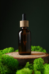 Moss, bottle of serum on wooden stand, dark green background