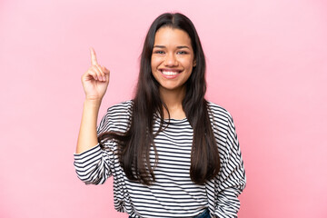 Young Colombian woman isolated on pink background pointing up a great idea