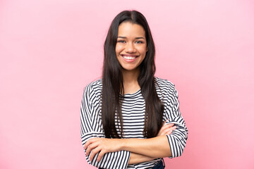 Young Colombian woman isolated on pink background keeping the arms crossed in frontal position