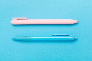 Pastel coloured pens on color backgroung, top view