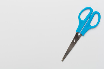 Blue scissors on color backgroung, top view