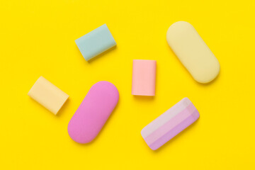 Colorful erasers on color backgroung, top view