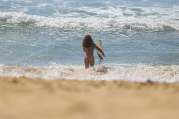 Jovem e linda, a mulher brasileira mostra toda sua destreza ao aproveitar o mar na praia paradisíaca para surfar. Quebra barreiras e revela que as mulheres também mandam muito bem nesse esporte.