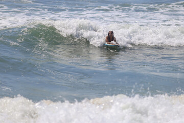 Jovem e linda, a mulher brasileira mostra toda sua destreza ao aproveitar o mar na praia paradisíaca para surfar. Quebra barreiras e revela que as mulheres também mandam muito bem nesse esporte.