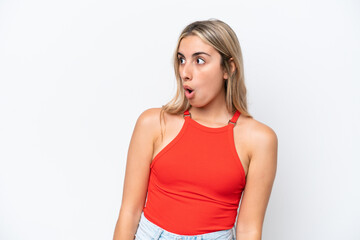 Young caucasian woman isolated on white background doing surprise gesture while looking to the side
