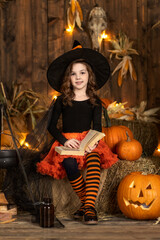 Cute little witch girl posing in halloween scenery. Halloween Party.