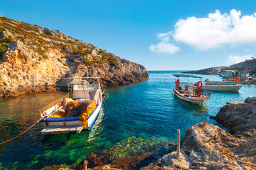 Cozy rocky Porto Roxa beach with boats in the bay, beautiful colored Ionian sea in west Zakynthos, Zakynthos island