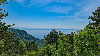 A panoramic view on the Mediterranean Sea in Croatia from Vojak. The mountain is overgrown with lush green plants. Few islands in the back. Early morning hiking by the sea. Clear, blue sky. Remedy