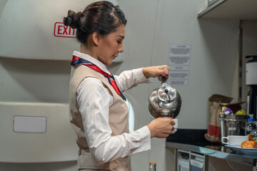 Flight attendants prepare meals, snacks and beverages during flight on the airline serving...