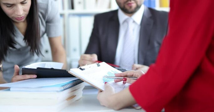 People in the office look at documents with graphs, close-up. Falling economic indicators, market collapse