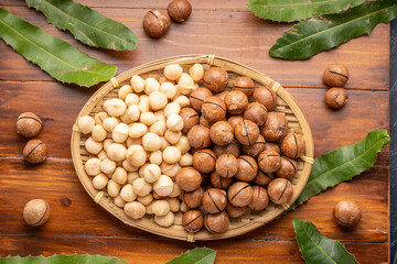 Roasted Macadamia nut in wooden plate on wooden background.