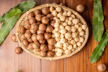 Roasted Macadamia nut in wooden plate on wooden background.